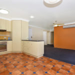 Yellow kitchen with orange feature wall